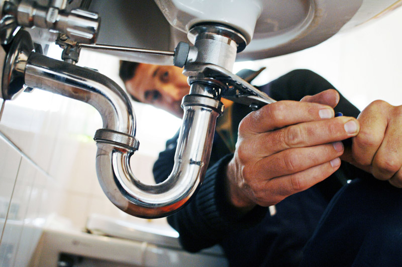 Just Plumbing plumber repairing a sink drain